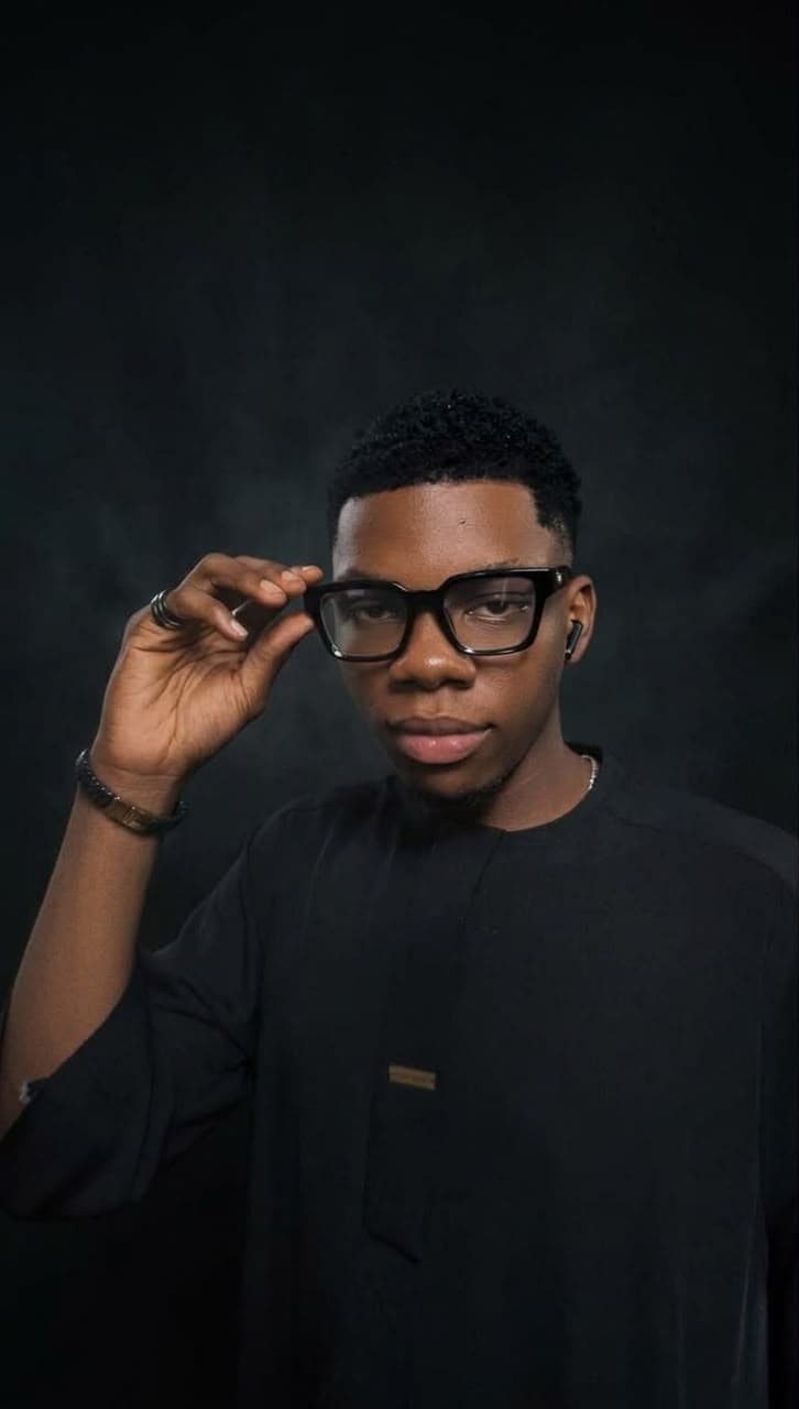 Portrait of Ifeanyi Onyekwelu, full-stack engineer, adjusting his glasses